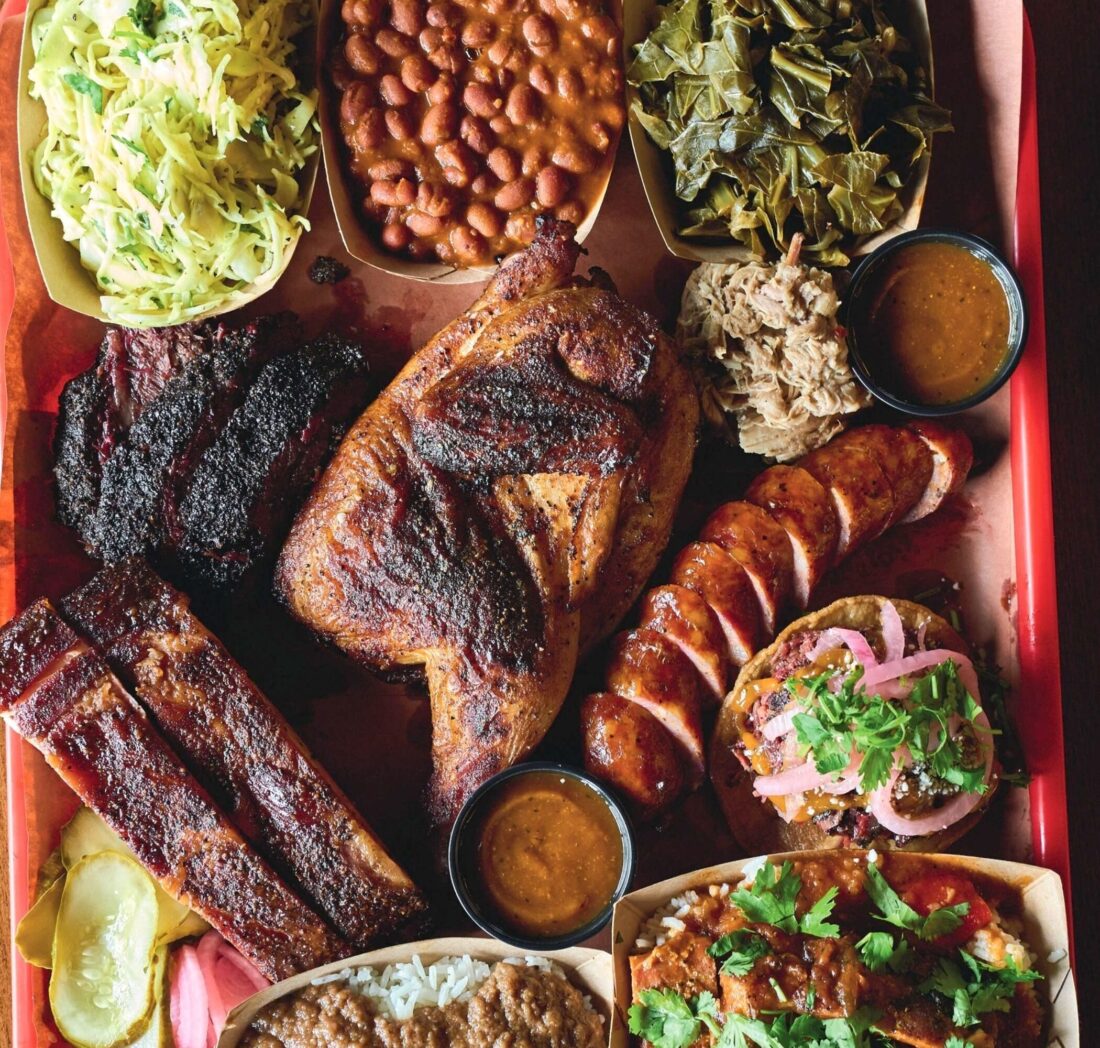 A sampler tray from the Puerto Rican-influenced Palmira, loaded with chicken, sausage, ribs, beef cheeks, and sides.