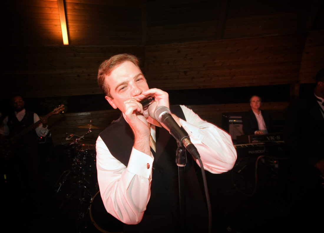 a man plays a harmonica