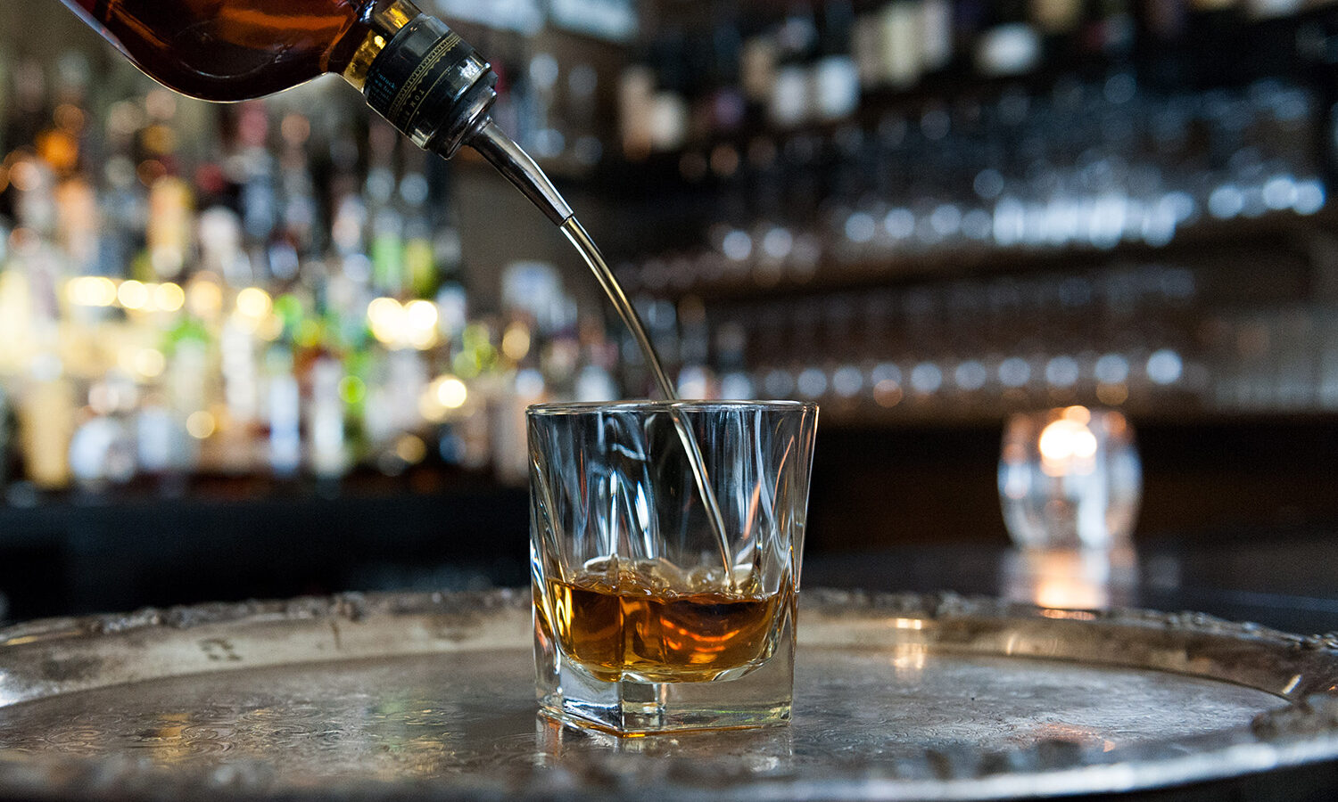 Bourbon being poured into a cocktail glass