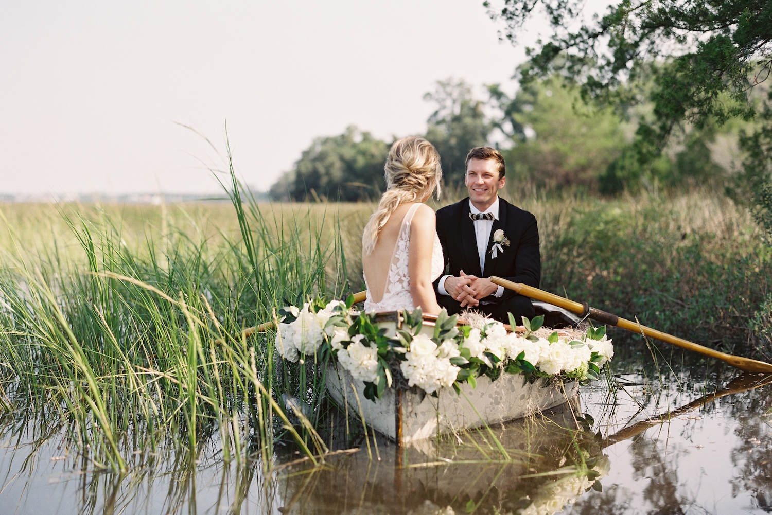 a bride and groom in a rowboat