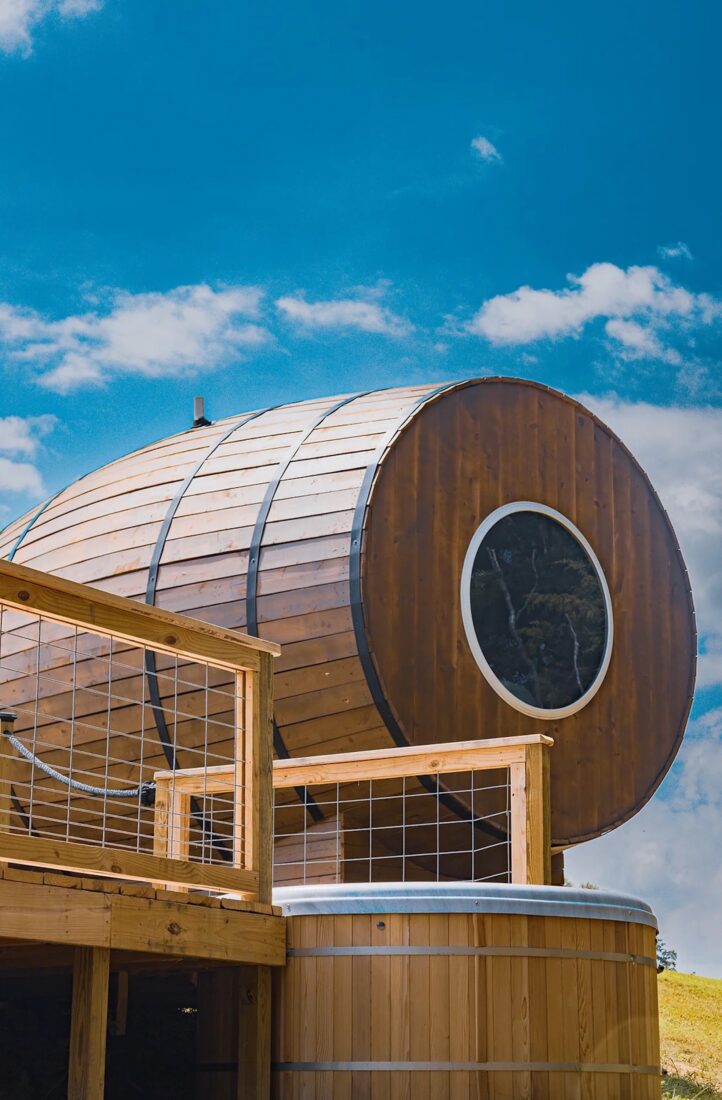 A cabin shaped like a bourbon barrel with a circular window