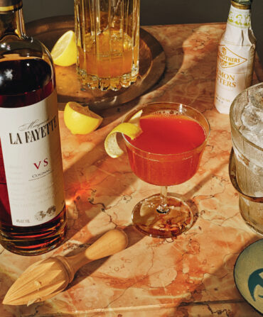 A cognac cocktail with a lemon garnish