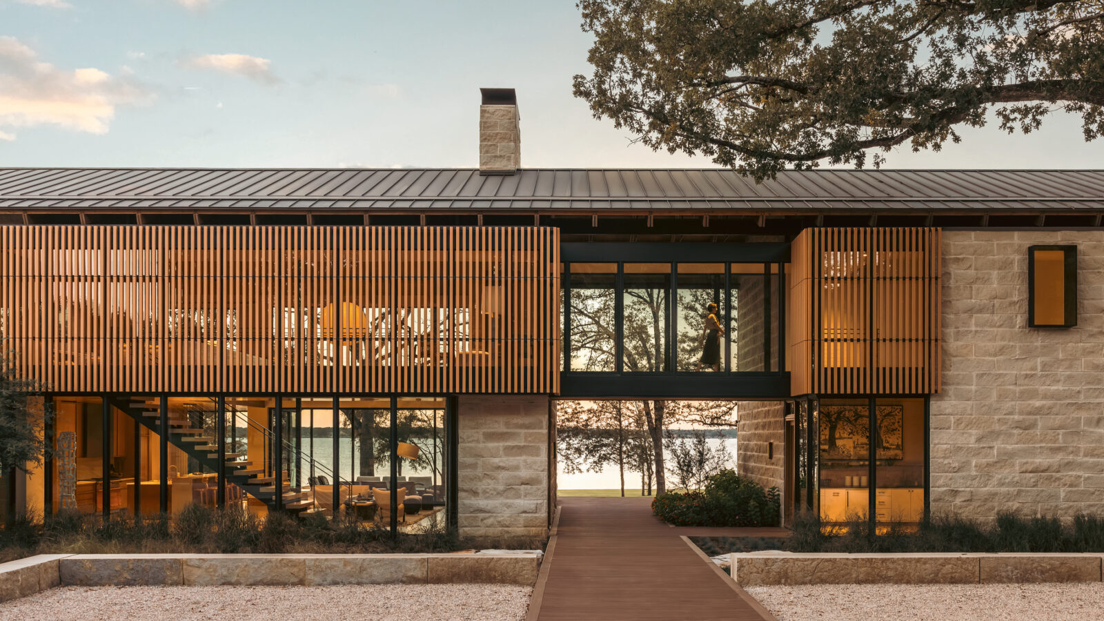 A lake house on the water with stone and wood textures