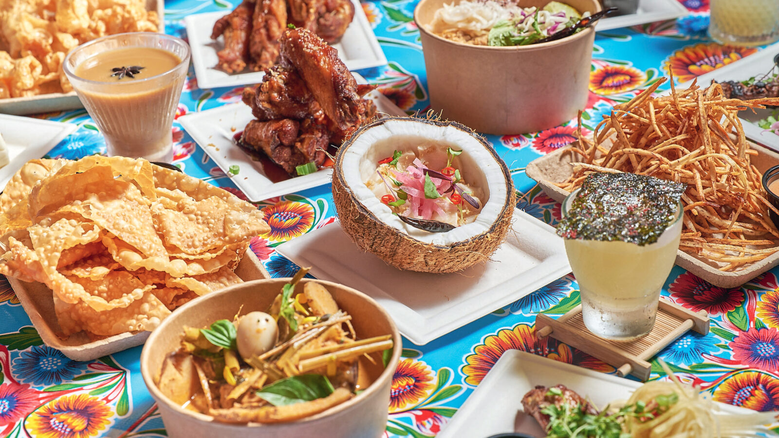 Coconut escolar ceviche, caramel fish sauce wings, and taro fries on a table