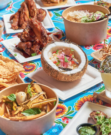 Coconut escolar ceviche, caramel fish sauce wings, and taro fries on a table