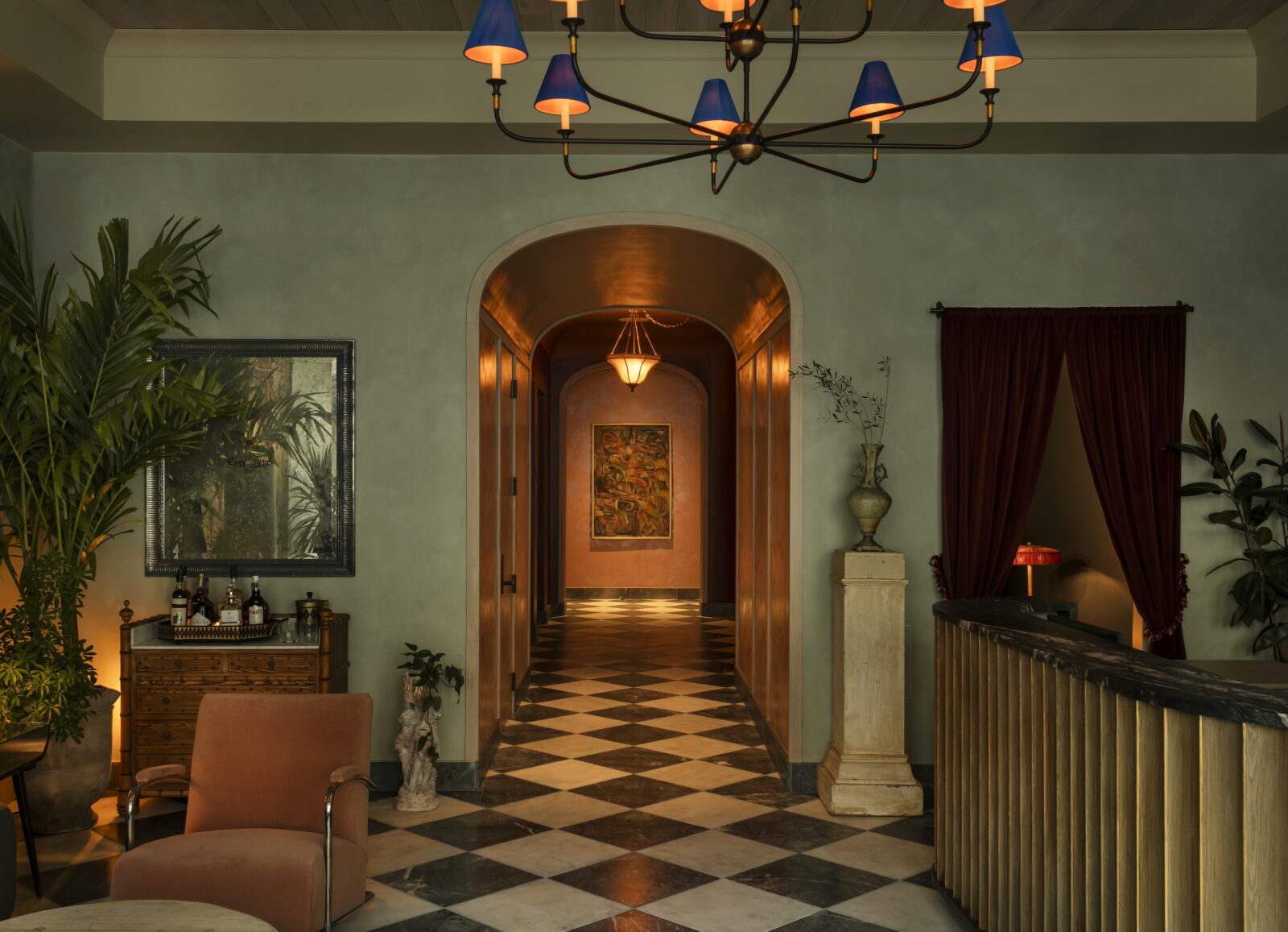 Inside a hotel lobby with checkered floors, green walls, and an arched entryway