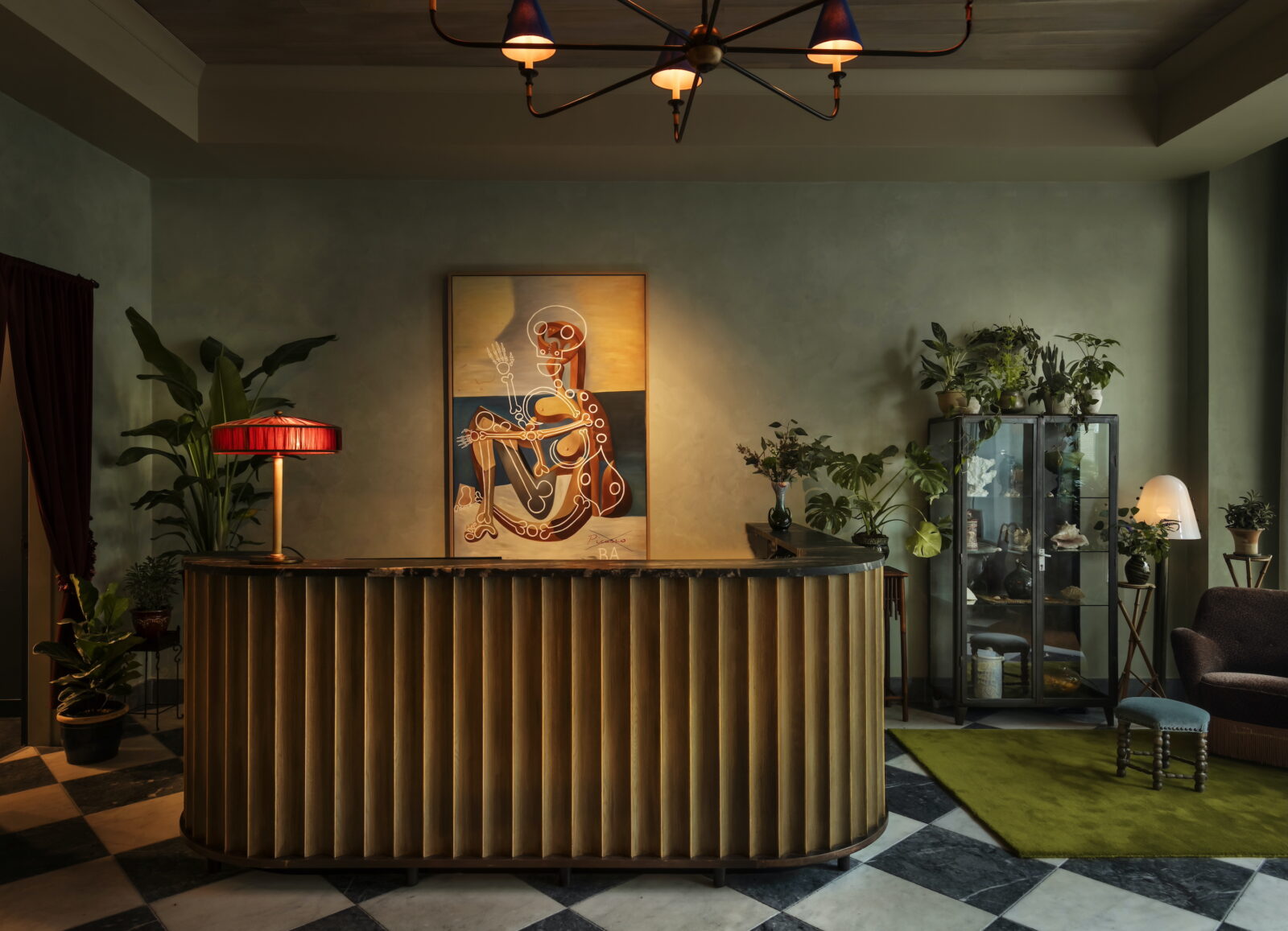 A lobby check in counter with green walls and a painting